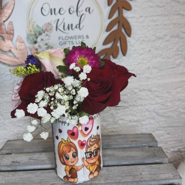 Bouquet of red roses and pink flowers in a printed gift cup
