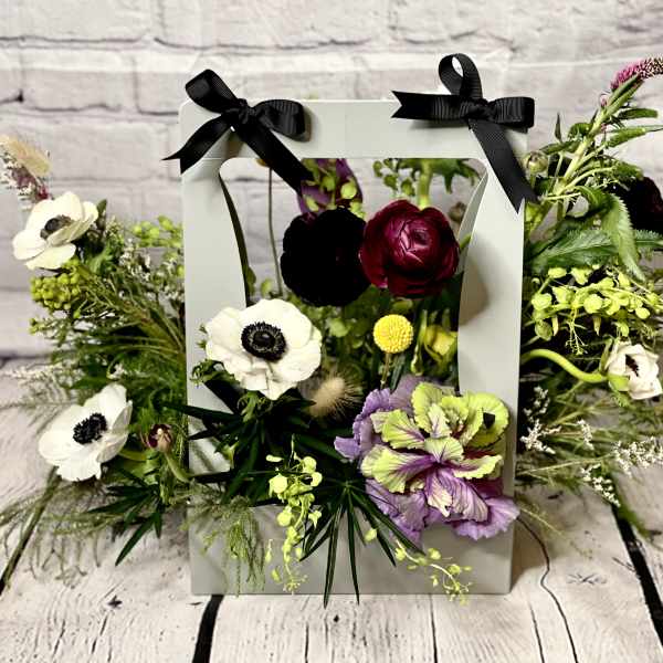 Floral arrangement in a white frame box with black bows