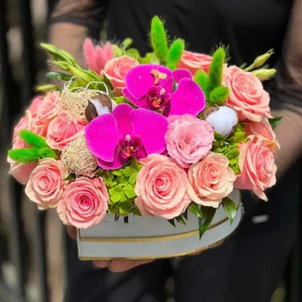 Pink roses and bright orchids arranged in a box