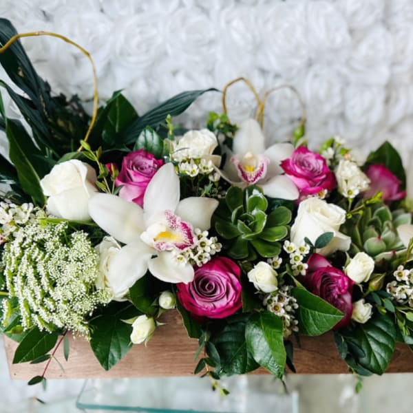 Pink and white roses with white orchids in a wooden box