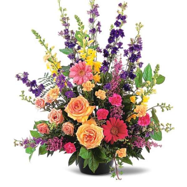 Mixed bouquet of roses, gerbera daisies, and purple spikes in a black vase