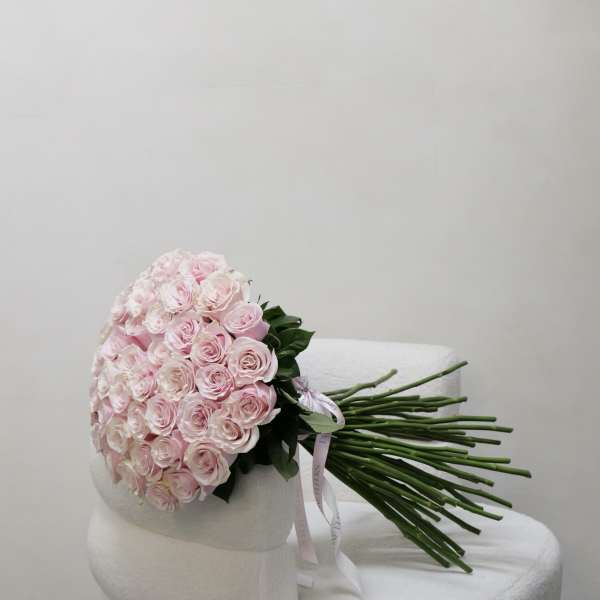 Bouquet of pale pink roses wrapped in white paper