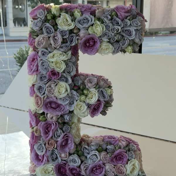 Large floral letter "F" covered in pastel roses