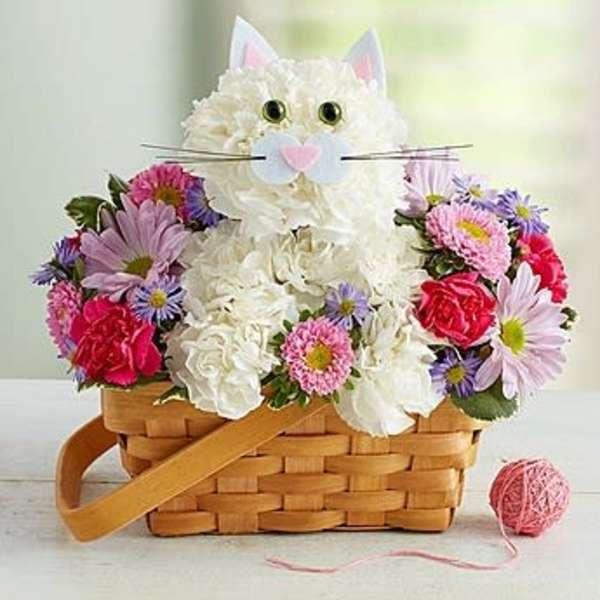 Flower basket arranged as a cat with white blooms and colorful daisies