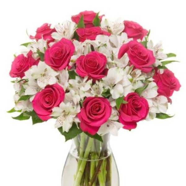 Pink roses and white alstroemeria in a clear glass vase