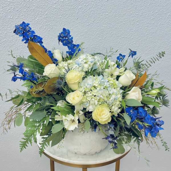 Blue and white floral arrangement in a white vase