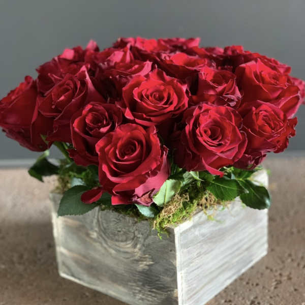 Red roses arranged in a square wooden box