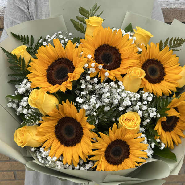 Bouquet of sunflowers and yellow roses with white filler flowers