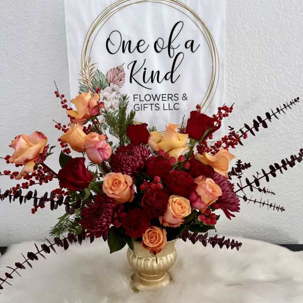 Bouquet of peach and red roses in a gold vase