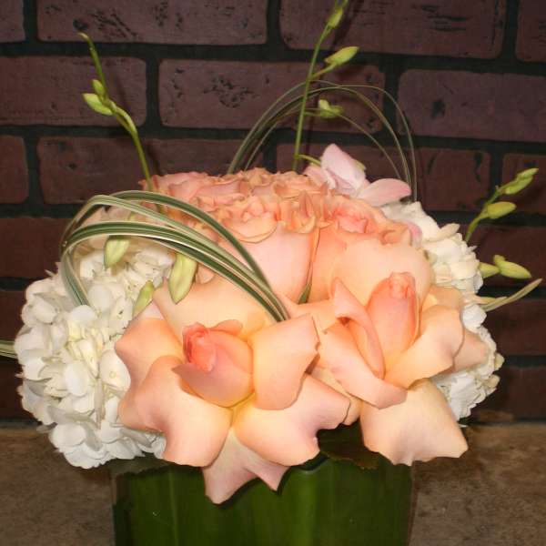 Peach roses and white hydrangeas in a green vase