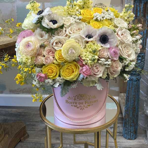Large pastel flower arrangement in a pink hatbox