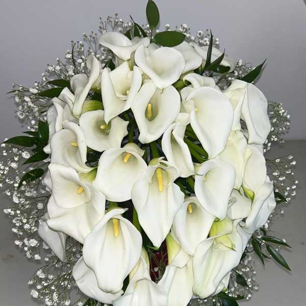 Bouquet of white calla lilies with baby's breath and greenery