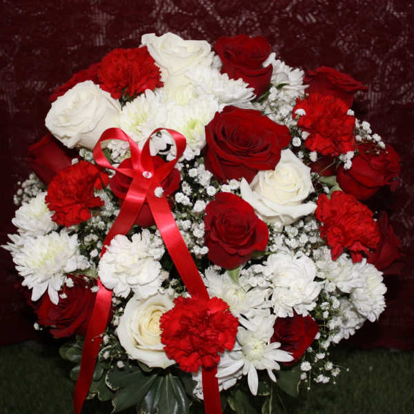 Red and white rose bouquet with carnations and a red ribbon
