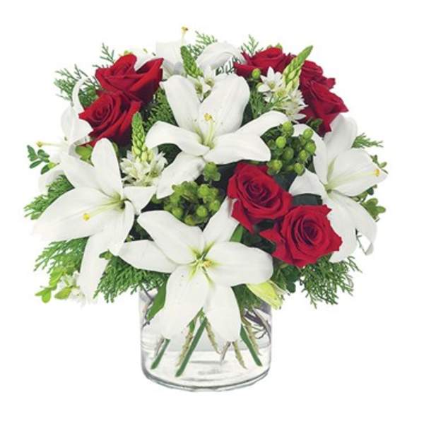 Red roses and white lilies arranged in a clear glass vase