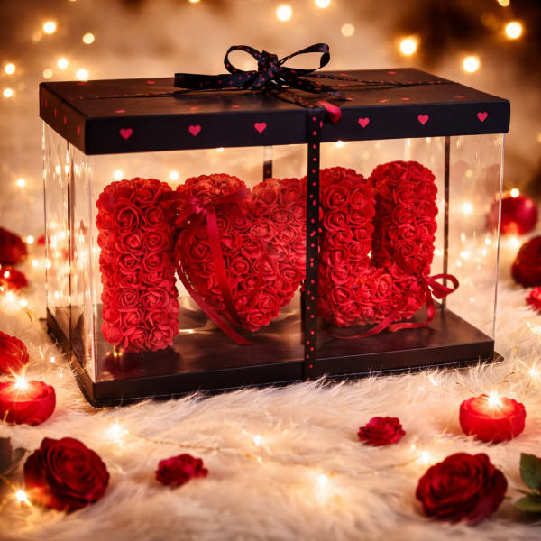 Red rose arrangement spelling "I LOVE U" in a clear gift box