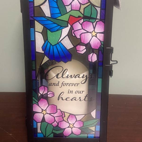 Decorative memorial lantern with floral stained-glass panels and a handle