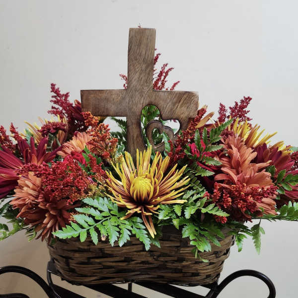 Basket arrangement with chrysanthemums and a wooden cross centerpiece