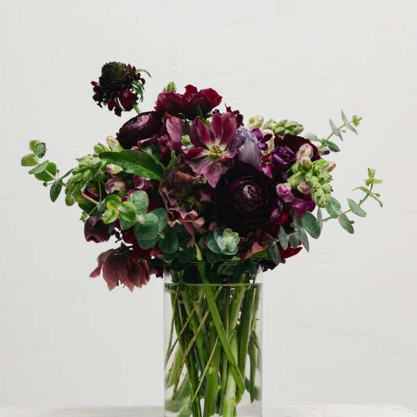Dark burgundy bouquet in a clear glass vase