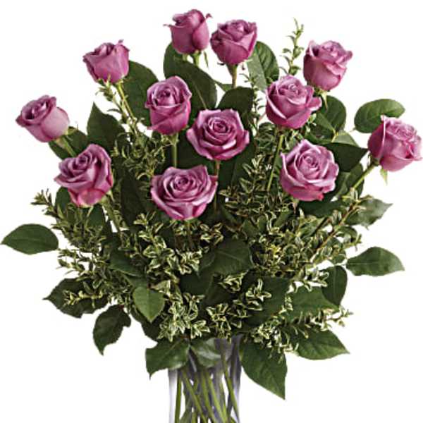 Tall arrangement of lavender roses in a clear glass vase