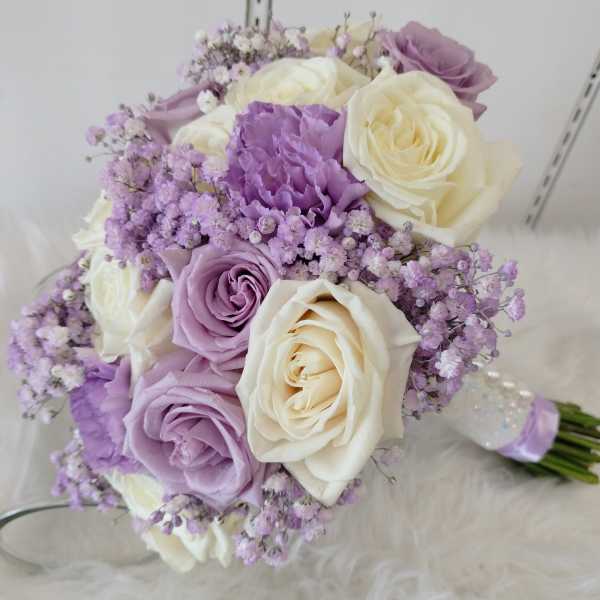 Bouquet of cream and lavender roses with small purple filler flowers