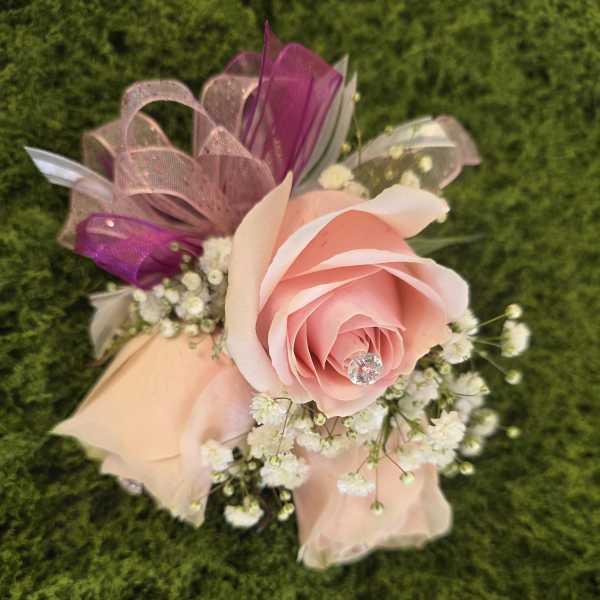 Pink rose boutonniere with baby's breath and ribbon accents