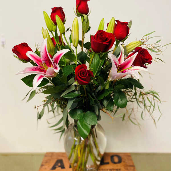 Red roses and pink lilies in a clear glass vase