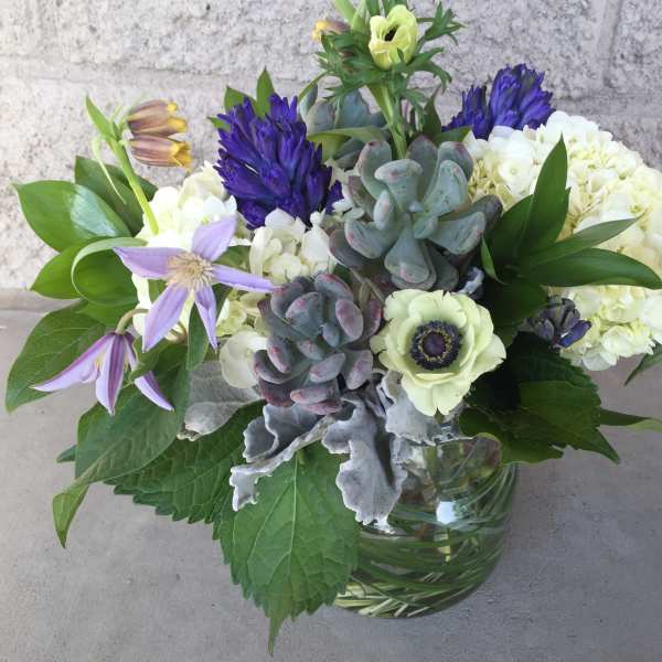 Mixed bouquet with purple and white flowers in a glass vase