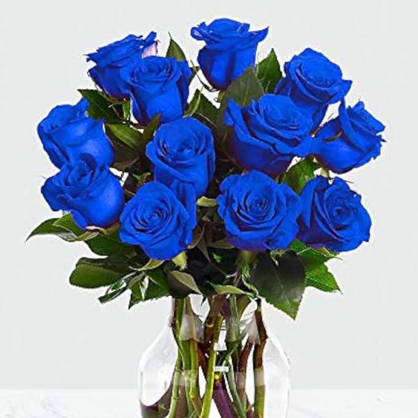 Blue roses arranged in a clear glass vase