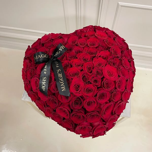 Heart-shaped bouquet of red roses with a black ribbon