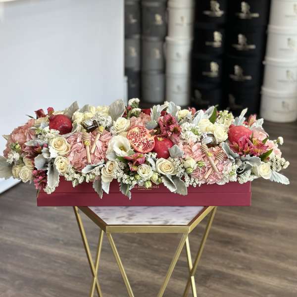 Long floral box arrangement with roses, hydrangeas, and pomegranates