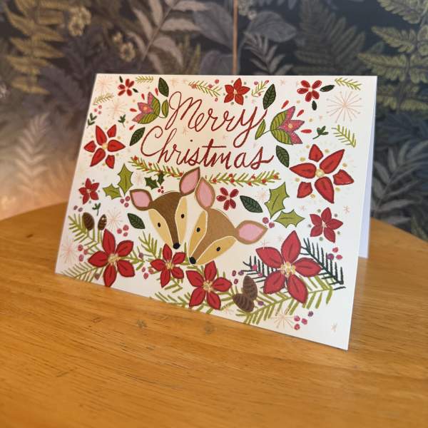 Christmas card with deer and red floral decorations