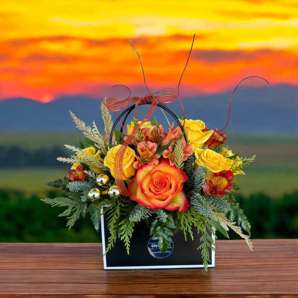 Arrangement of yellow and orange roses in a black handled box