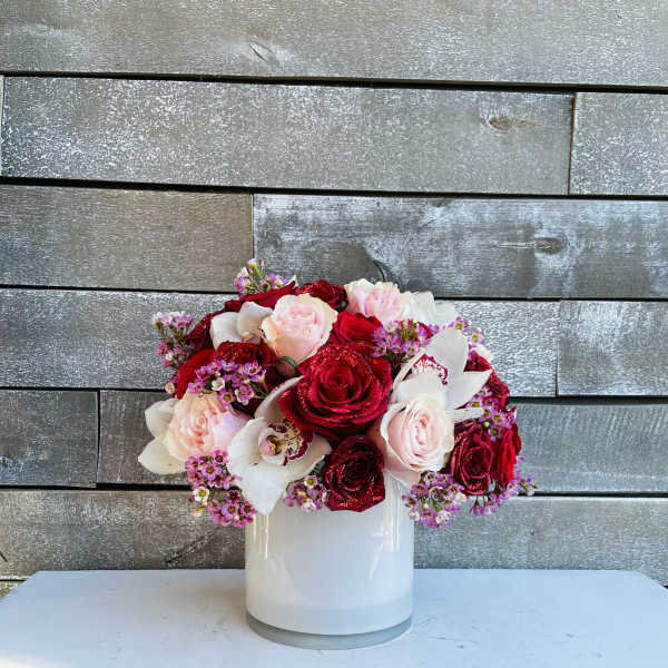 Bouquet of red and blush roses in a white vase