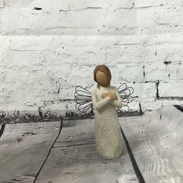 Small angel figurine with wire wings on a wooden surface