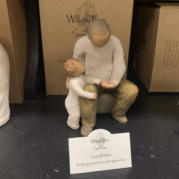 Wooden grandfather and child figurine on a shelf
