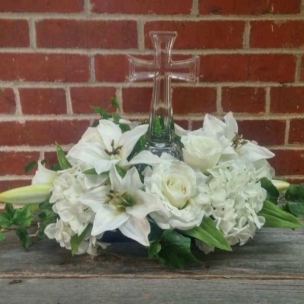White floral arrangement with a clear glass cross centerpiece