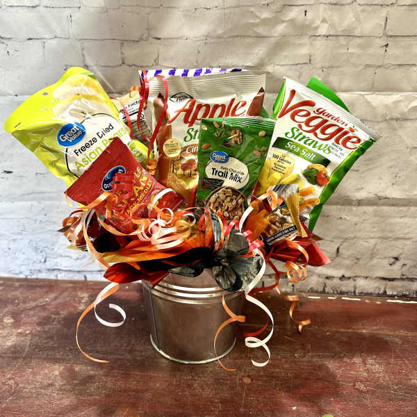 Assorted snack bags arranged in a metal bucket with curled ribbons