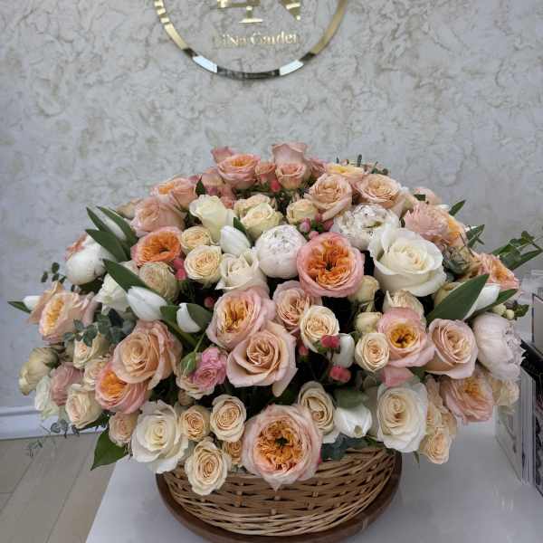Large basket arrangement of peach, pink, and white roses