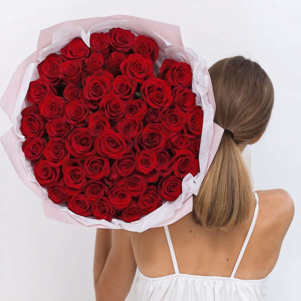 Large bouquet of red roses wrapped in pale pink and white paper