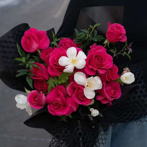 Bouquet of hot pink roses with white accent flowers wrapped in black paper