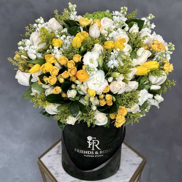 Large bouquet of yellow and white roses in a black hat box