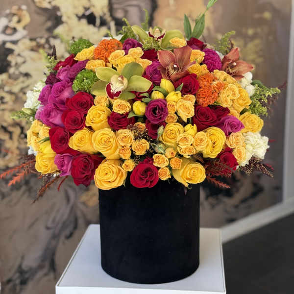 Large mixed bouquet of roses and orchids in a black box