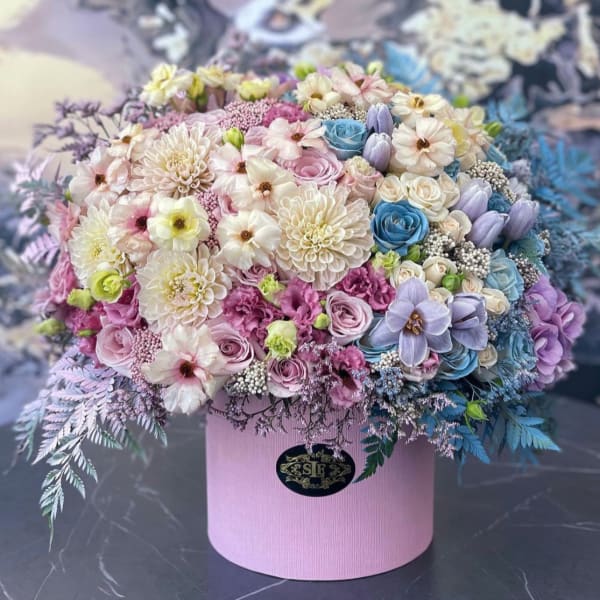 Pastel mixed flower arrangement in a pink hat box