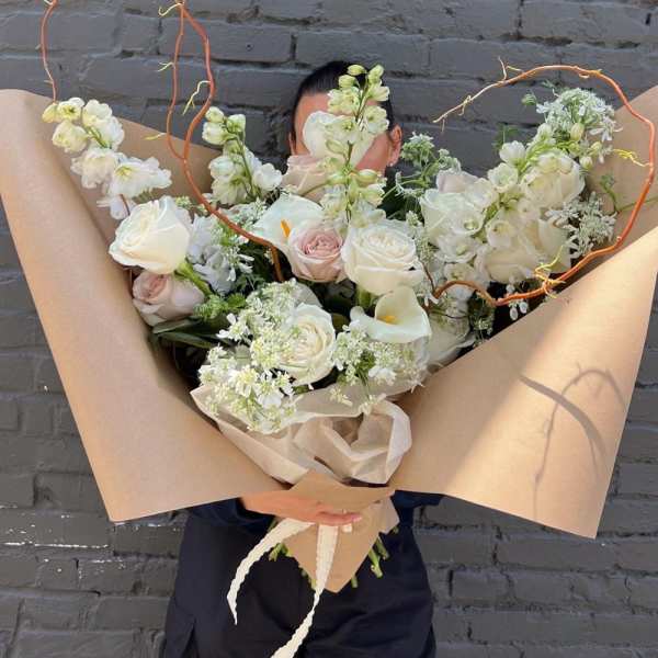 Large bouquet of white and blush roses with calla lilies and airy white blooms