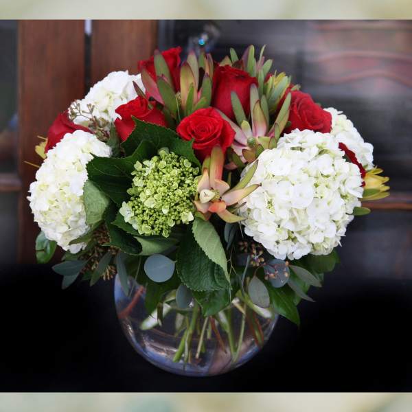 Bouquet of red roses and white hydrangeas in a glass vase