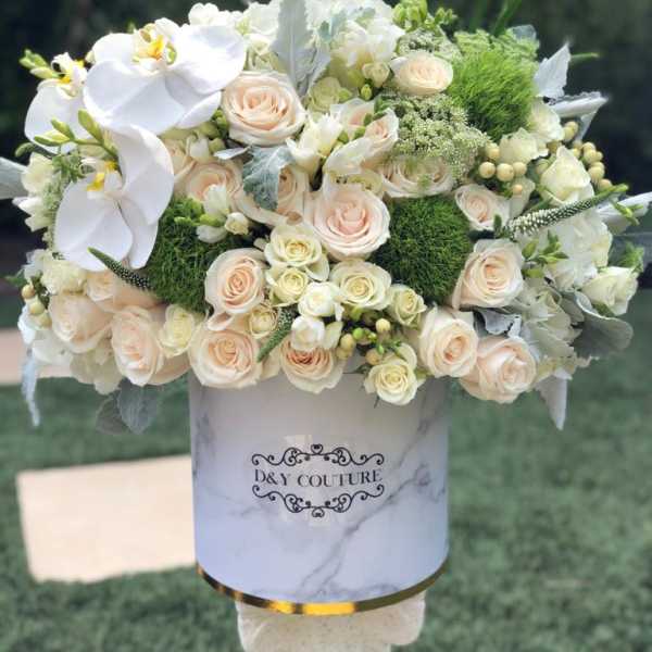 White and blush bouquet with orchids and roses in a marble-print box