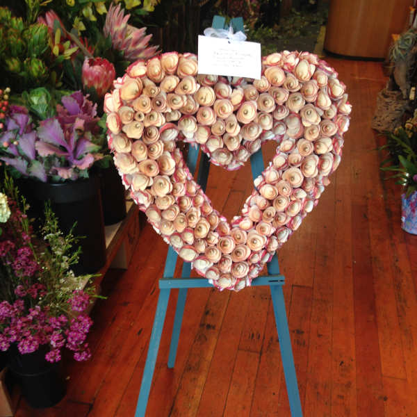 Heart-shaped floral arrangement on a blue easel stand