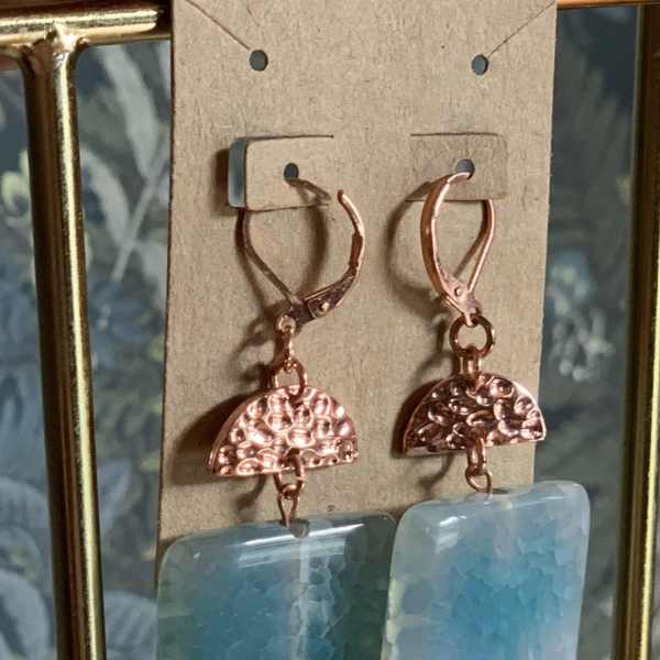 Pair of dangling earrings with blue rectangular stones and copper-toned metal accents
