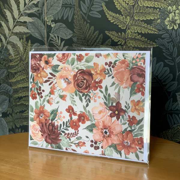 Floral greeting card with coral and burgundy flowers in a clear sleeve