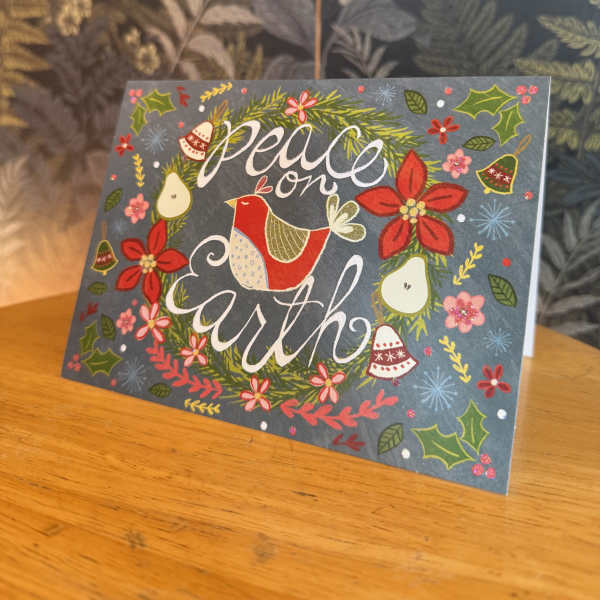 Holiday card with a bird and the words "peace on earth"